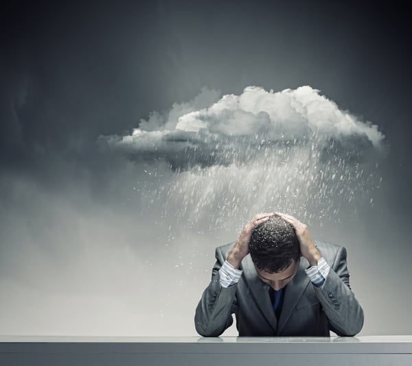 Businessman sitting wet under rain